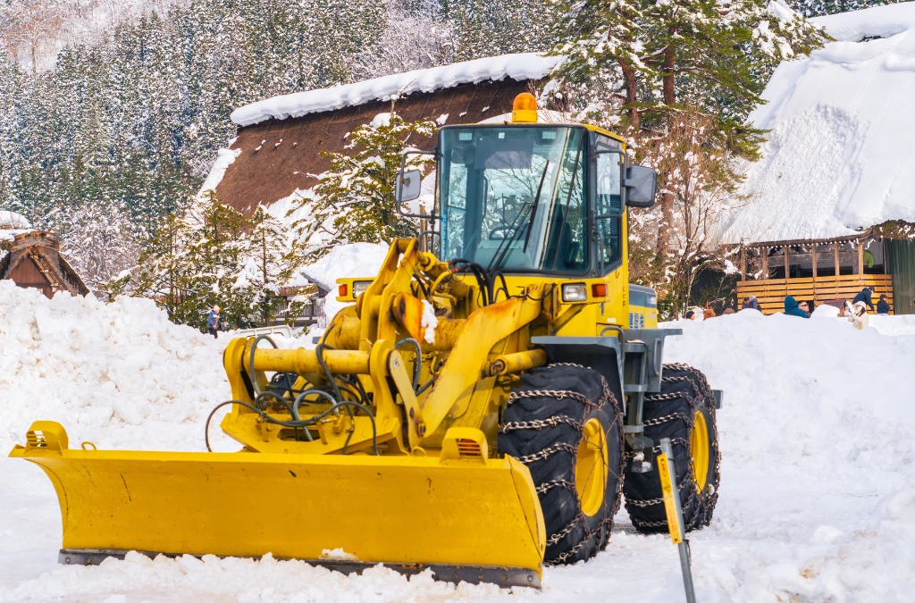 Urban snow removal with red tractor plowing streets during heavy snowfall