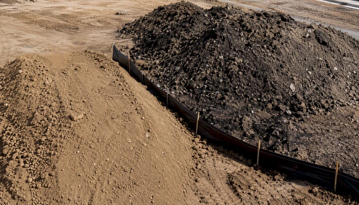Separated piles of clean fill and contaminated soil