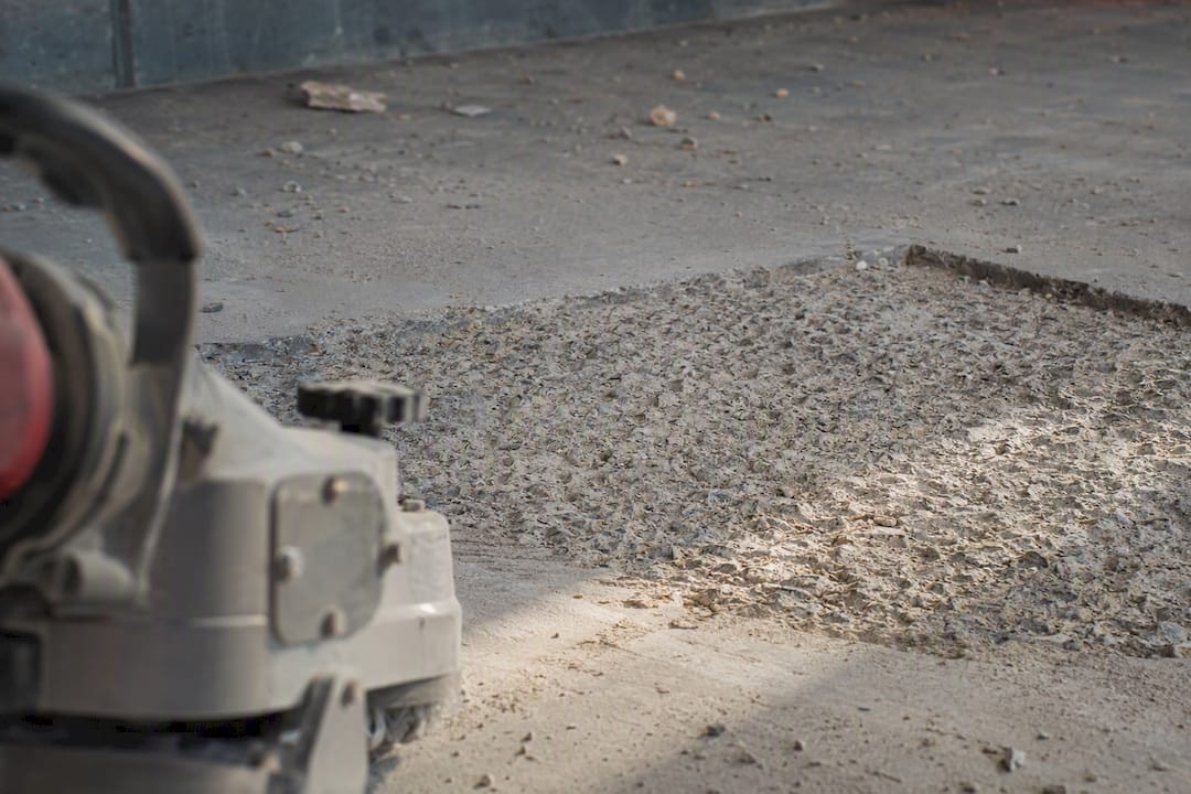 Concrete surface roughened for patch bonding