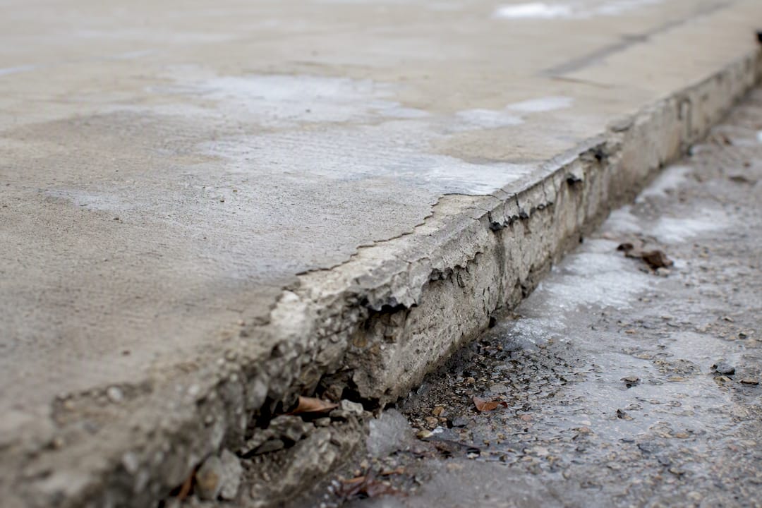 Failed concrete patch with delaminated edge
