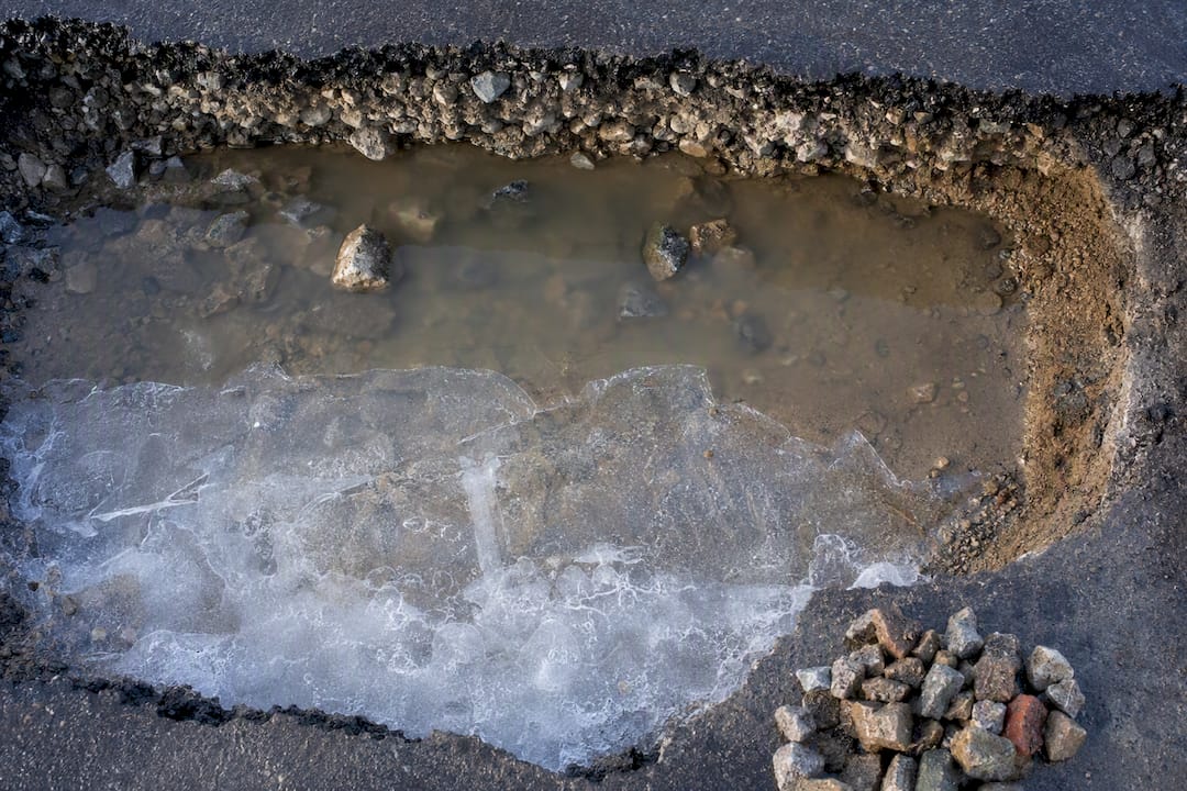 Standing water over frozen asphalt subbase
