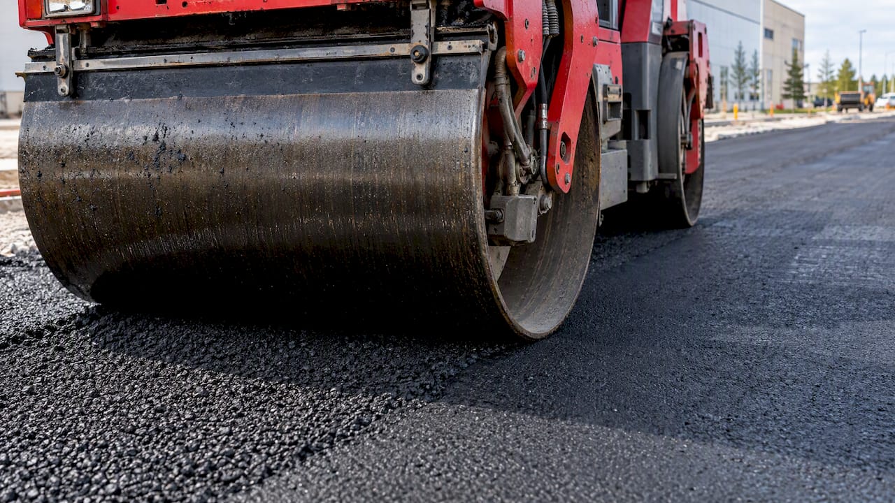 Asphalt roller compacts a fresh pavement lift