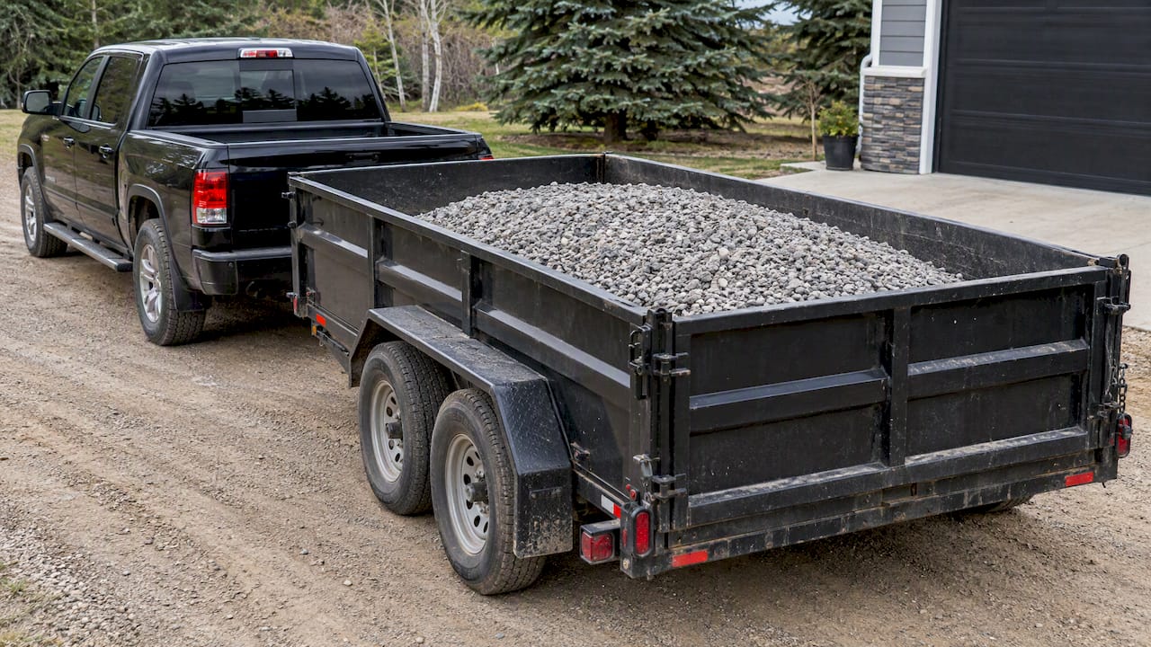 Pickup towing a gravel-filled utility trailer