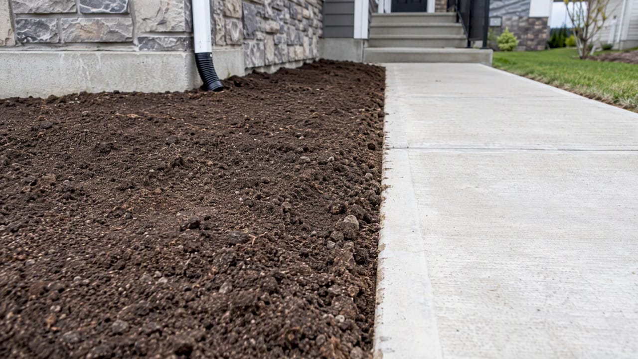 Graded soil beside completed concrete walkway